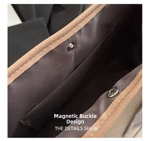 Detail of magnetic buckle closure on canvas and leather tote bag with fabric lining