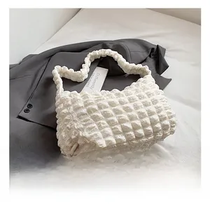 Detail showing the white bubble pleated texture and woven structure of the tote bag