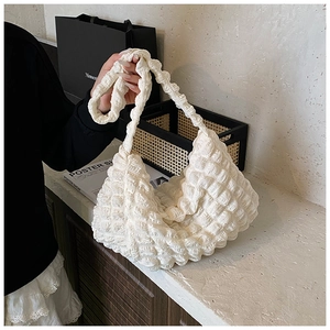 Detailed view of white bubble texture fabric on a stylish ruched cloud shoulder bag