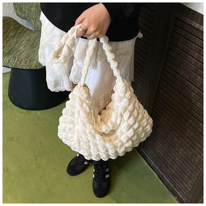 Close-up of white bubble pleated texture and soft cloud shape design on women's shoulder bag