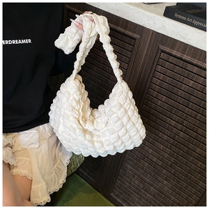 Detail of white bubble texture fabric on a stylish pleated hobo shoulder bag for women