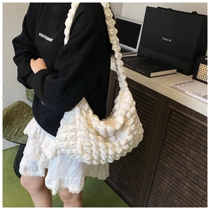 Detail showing white pleated cloud shoulder bag with textured elastic bubble fabric