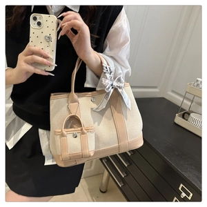 Detail of canvas tote bag with contrast faux leather trim and mini pouch accessory