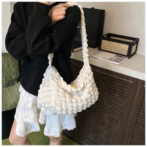 Detail showing white bubble textured popcorn fabric on a large crossbody bag strap