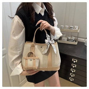 Canvas and leather tote bag detail with mini pouch and elegant heart pattern scarf accessory