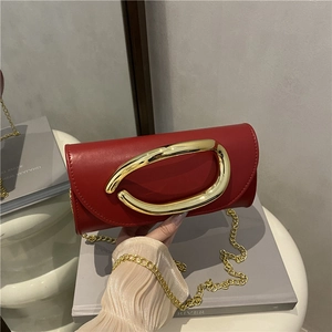 Modern red leather box handbag with bold gold oval buckle and fine metal chain strap