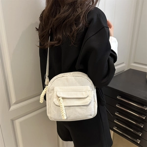 Minimalist white corduroy crossbody bag shown as a casual shoulder bag on a model