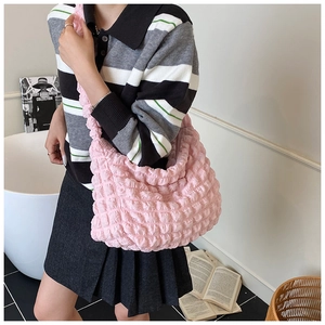 Detail of pink bubble textured shoulder bag with pleated fabric and crescent shape
