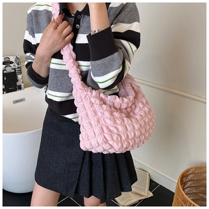Detail of light pink bubble texture shoulder bag showing soft ruched fabric and wide strap