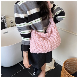 Detailed shot of pink bubble textured shoulder bag with pleated fabric on a model