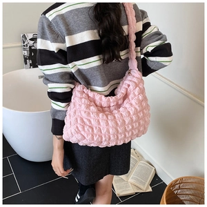 Macro detail of pink bubble-textured fabric on a stylish ruched shoulder bag