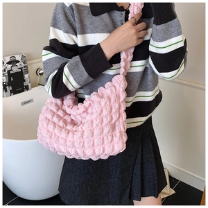Pink cloud puff shoulder bag featuring ruched texture shown worn by a model