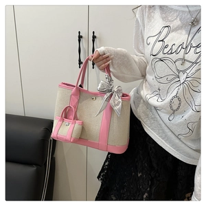 Pink canvas tote bag with mini pouch and silk scarf detail held by model in home setting