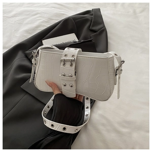 Detail of white crocodile pattern baguette bag featuring silver metal eyelets and square buckle