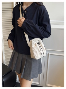 Détail du sac à bandoulière en toile blanc cassé avec cordon et sangle réglable