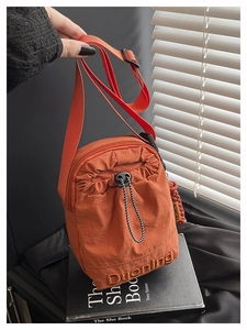 Détail du sac bandoulière en nylon orange avec poche à cordon et sangle réglable