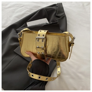 Detail of gold crocodile texture leather bag featuring large silver buckle and rivets