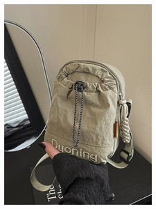 Détail du sac à bandoulière en nylon vert clair avec cordon et broderie Dyoning