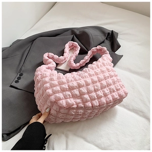 Detail shot of a pink bubble-textured tote bag showing the soft pleated cloud fabric finish