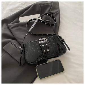 Detail of crocodile pattern underarm bag with metal buckle and interior phone storage space