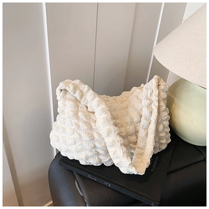 Close-up of cream white tote bag featuring bubble pleated texture and soft fabric finish