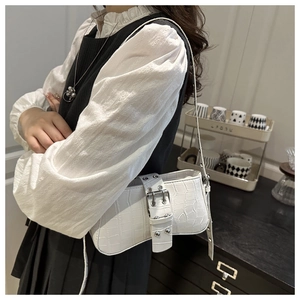 Close-up of a white crocodile texture shoulder bag with stylish wide buckle detail