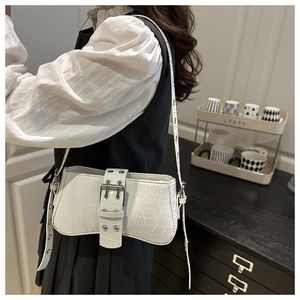 Detail of white crocodile embossed baguette bag with silver buckle and adjustable strap