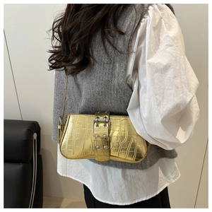 Detail of metallic gold crocodile texture underarm bag with silver rivets and buckle