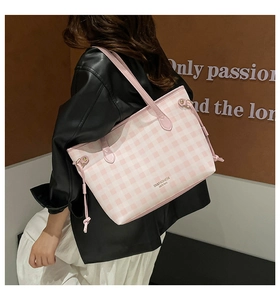Macro detail of a pink plaid tote bag featuring side drawstrings and logo lettering