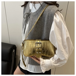 Detail of gold metallic crocodile pattern shoulder bag with silver rivet buckle and strap