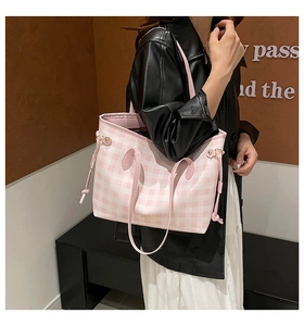 Detail of pink and white checkered tote bag with drawstring side and leather handle
