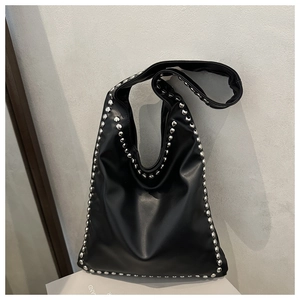 Close-up of black retro hobo bag with silver rivet studs and matte leather texture