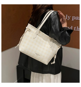 Dettaglio della borsa tote beige a scacchi con accenti a coulisse e scritta del marchio
