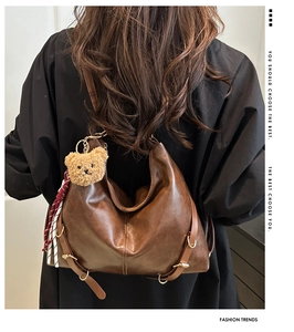 Gros plan sur un sac cabas vintage marron avec ours en peluche et sangle à carreaux