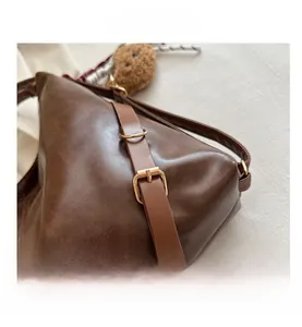 Détail du sac en cuir PU marron avec boucle dorée et charm ours en peluche