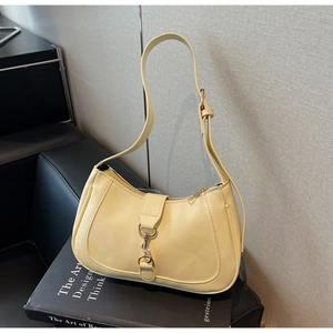 Détail du fermoir métallique et du cuir crème lisse sur ce sac à main hobo chic