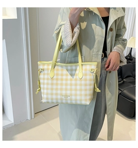 Detail of yellow checkered tote bag showing drawstring decor and leather shoulder strap
