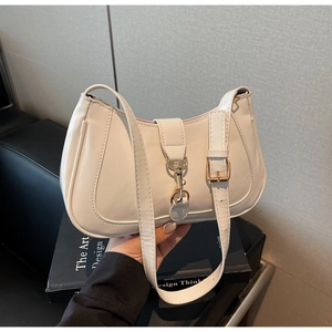 Détail d'un sac baguette en similicuir blanc avec boucle métallique et bandoulière chic