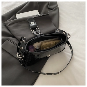 Detail of black crocodile texture baguette bag with silver studs and interior storage