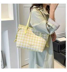 Detail of yellow checkered tote bag with side knot decor and long shoulder straps