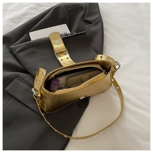 Interior view of golden crocodile embossed bag showing storage for wallet and makeup