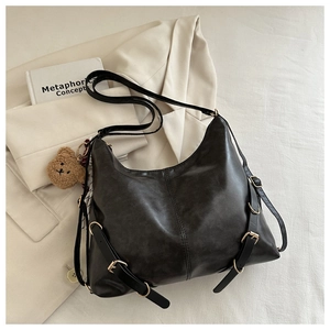 Détail du sac cabas rétro noir avec boucles dorées et charm d'ours en peluche