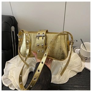 Macro detail of glossy gold crocodile pattern leather and silver buckle strap on the bag