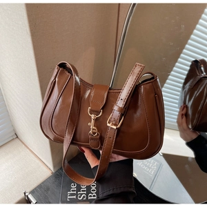 Détails du sac à bandoulière demi-lune marron foncé avec texture lisse et fermoir métal