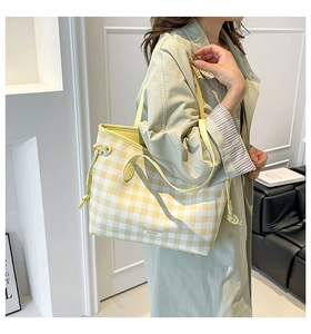Dettaglio della borsa tote a scacchi gialli con coulisse laterale e logo del brand
