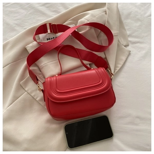 Red crossbody bag with wide strap and gold hardware shown next to a smartphone for size reference