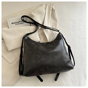 Détail du sac fourre-tout en cuir PU noir mat vintage sur blazer beige et tissus