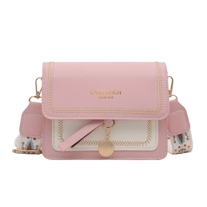 Pink and beige crossbody flap bag with a wide patterned strap and metal charm detail