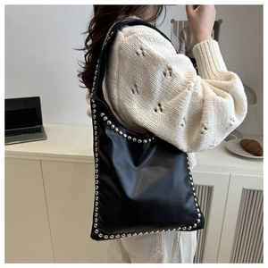 Close-up of black PU leather shoulder bag featuring vintage silver rivet studs detail