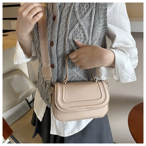 Detail of beige crossbody square bag with decorative stitching and wide shoulder strap
